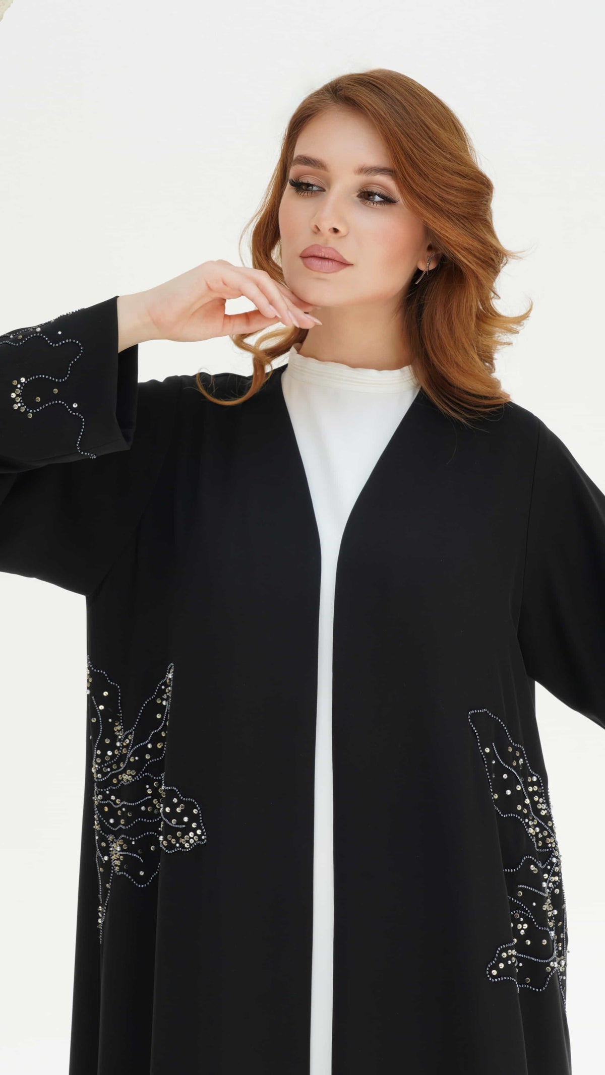 AZIZA | Noir Fleur Pose Minimal black luxury abaya with delicate floral detailing and clean structure