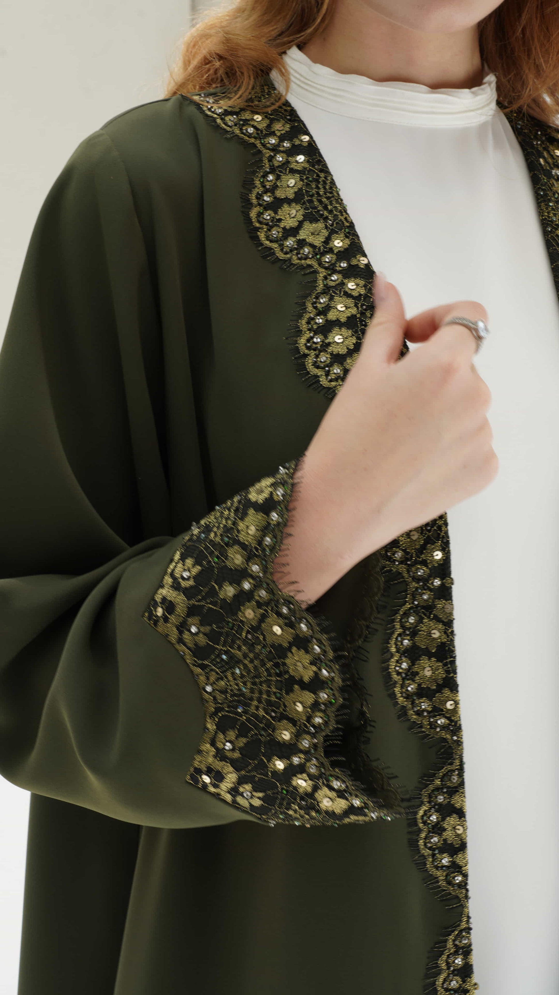 FARIDA | Imperial Olive Close up of black lace and gold embellishment on abaya