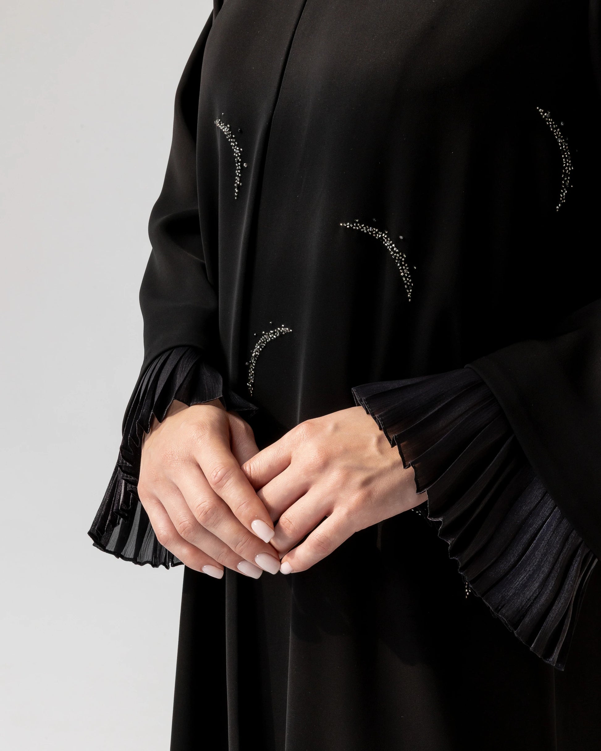 LUNARA Noir Crescent close-up featuring moon-inspired crystal detailing and elegant pleated sleeve cuffs