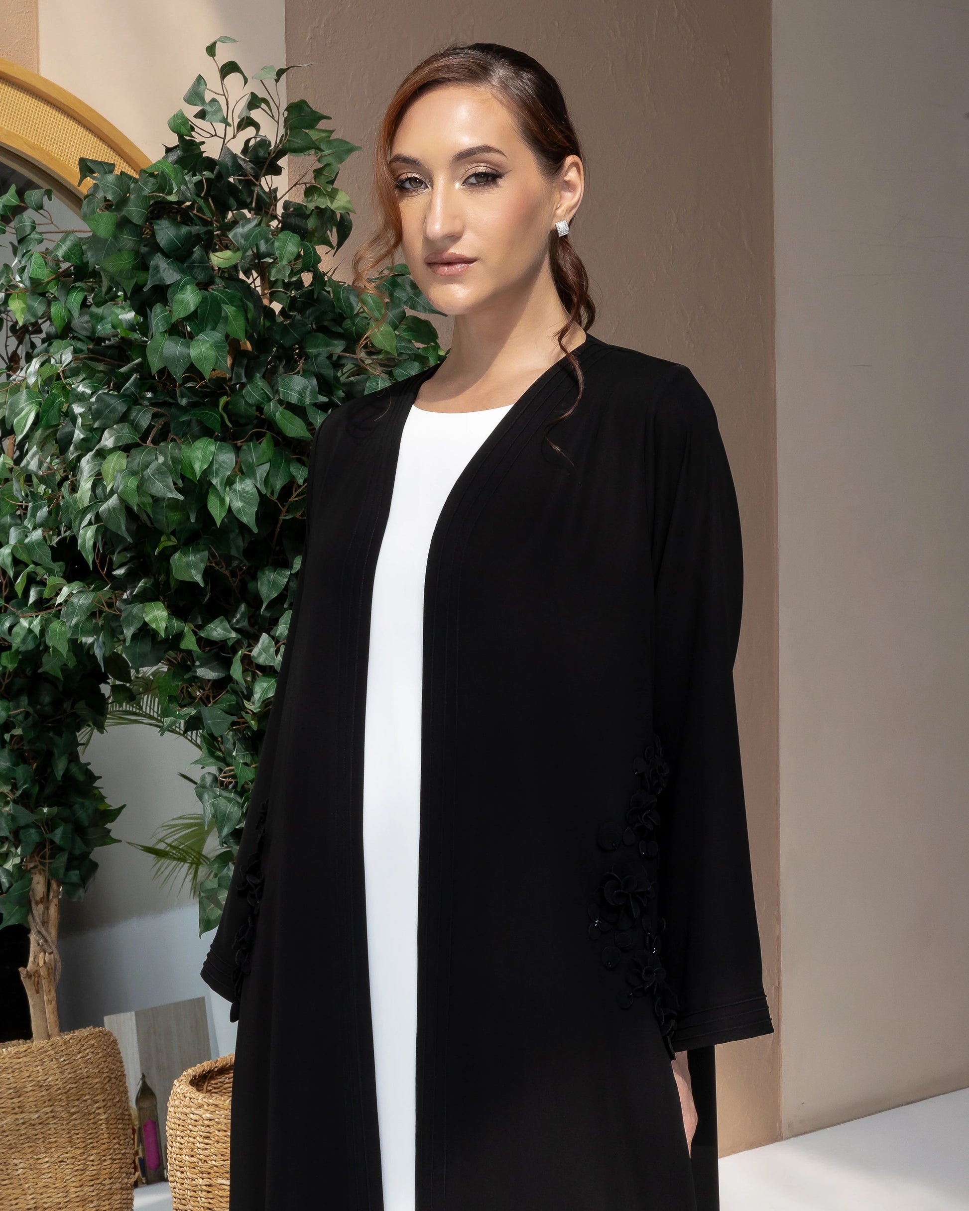MELINA Noir Blossom contemporary black abaya featuring refined floral appliqué and modern modest elegance