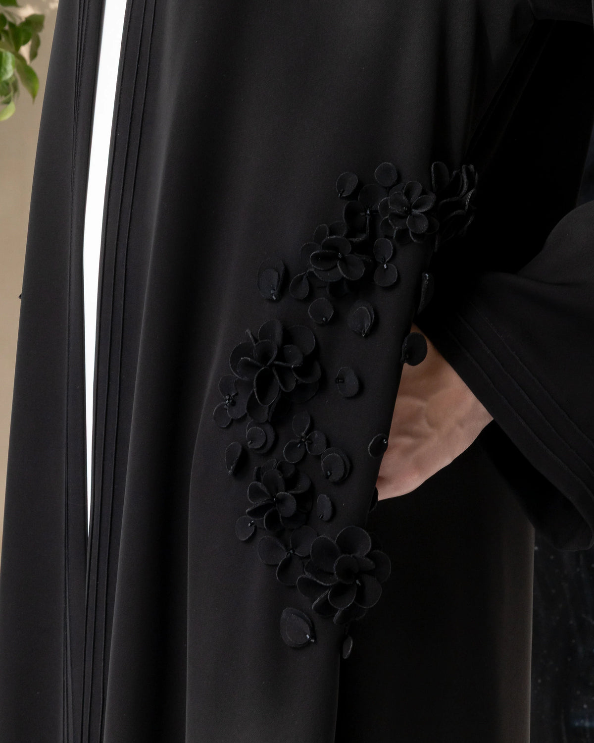 MELINA Noir Blossom close-up of handcrafted black 3D floral embellishments on premium luxury abaya