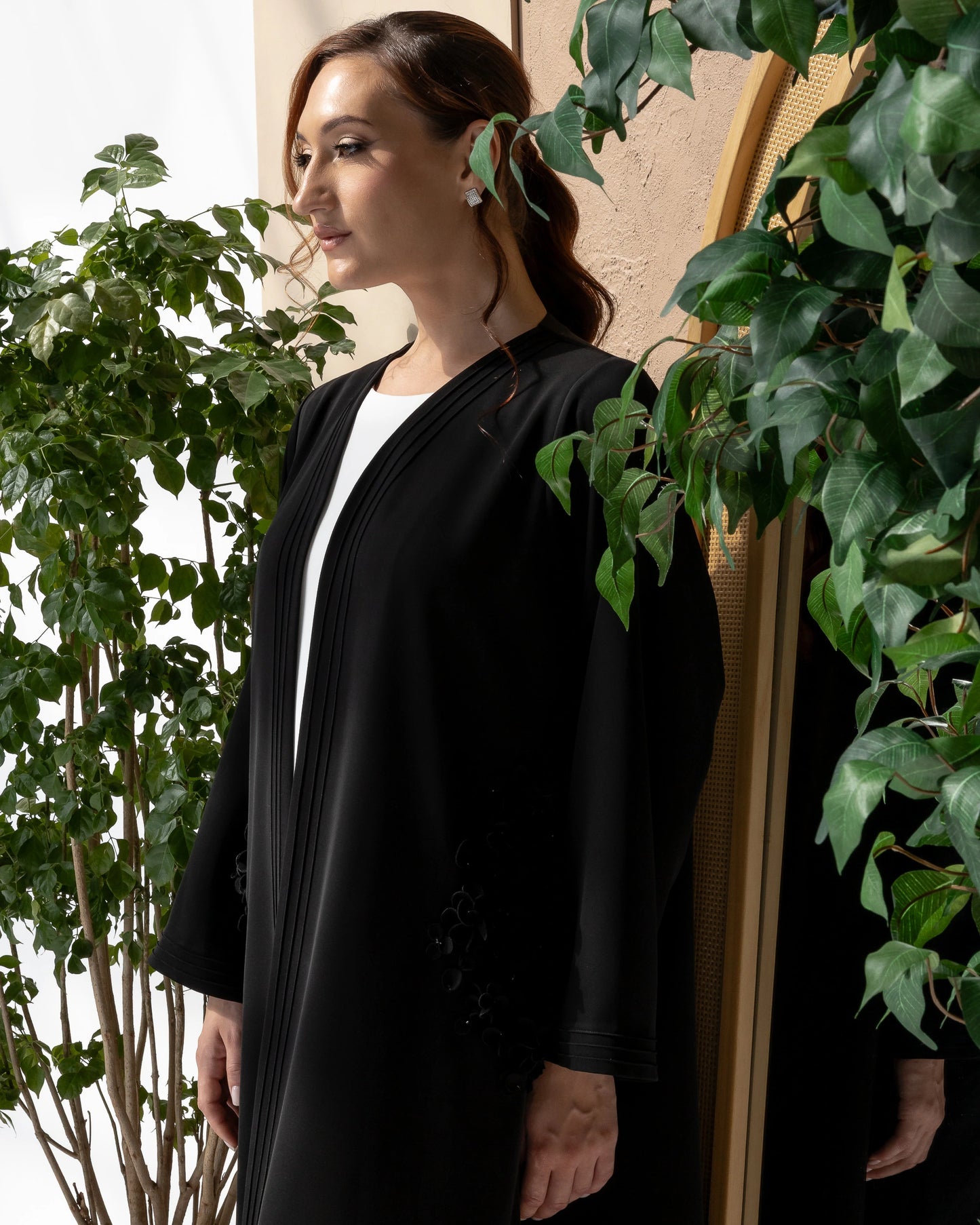 MELINA Noir Blossom side-view luxury abaya with graceful drape and monochrome floral couture accents