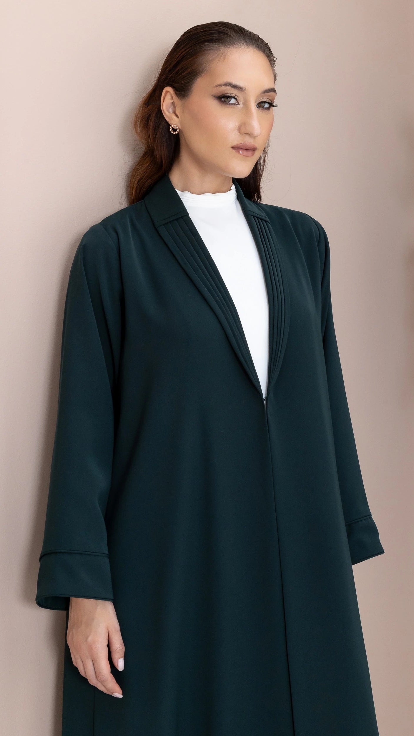 MIRAL Verde Royale close-up portrait showcasing refined pleated neckline craftsmanship