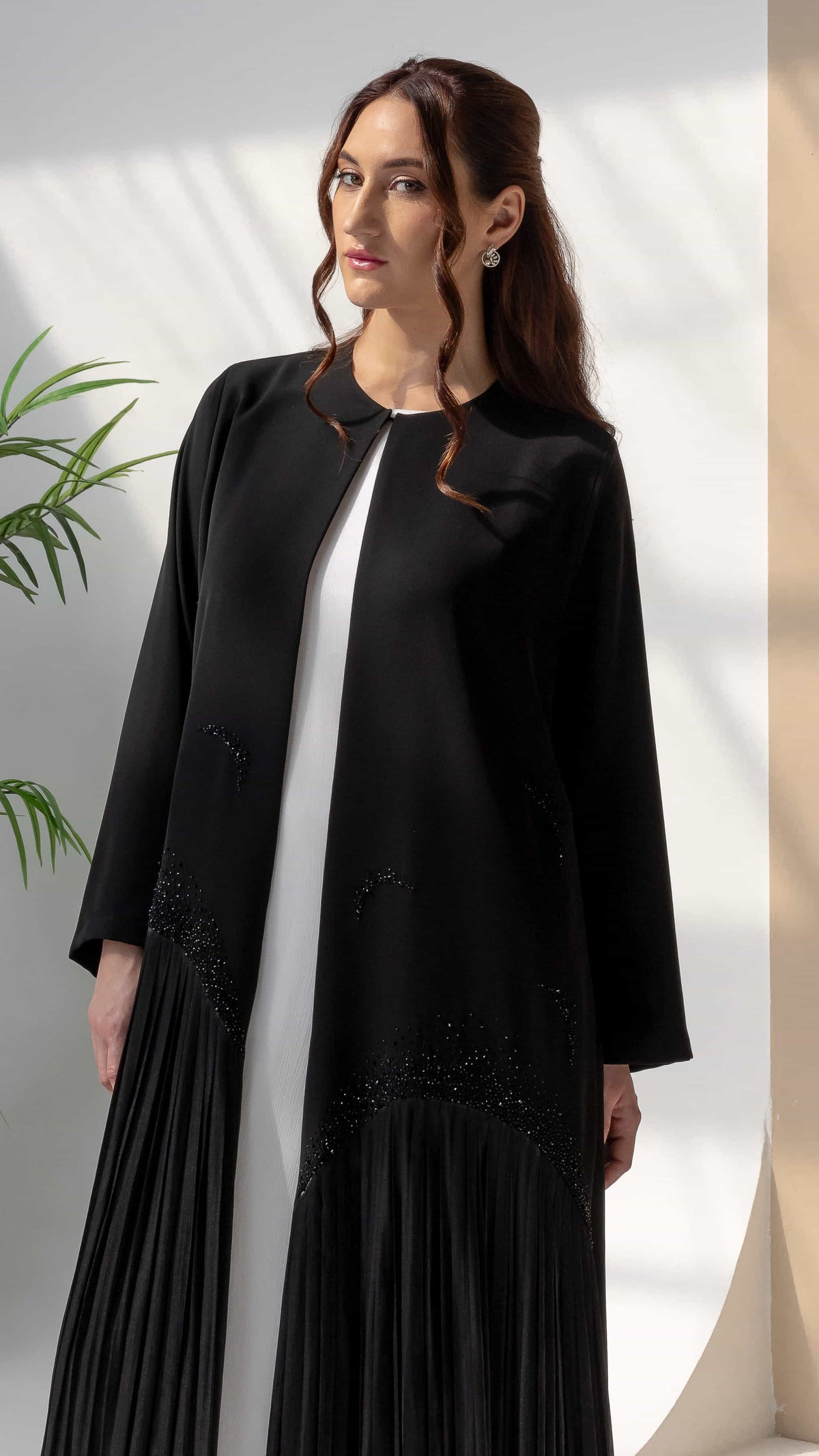 MIRA | Noir Shadow Luxe Side angle of Mira Noir Shadow Luxe abaya showing fluid pleated structure