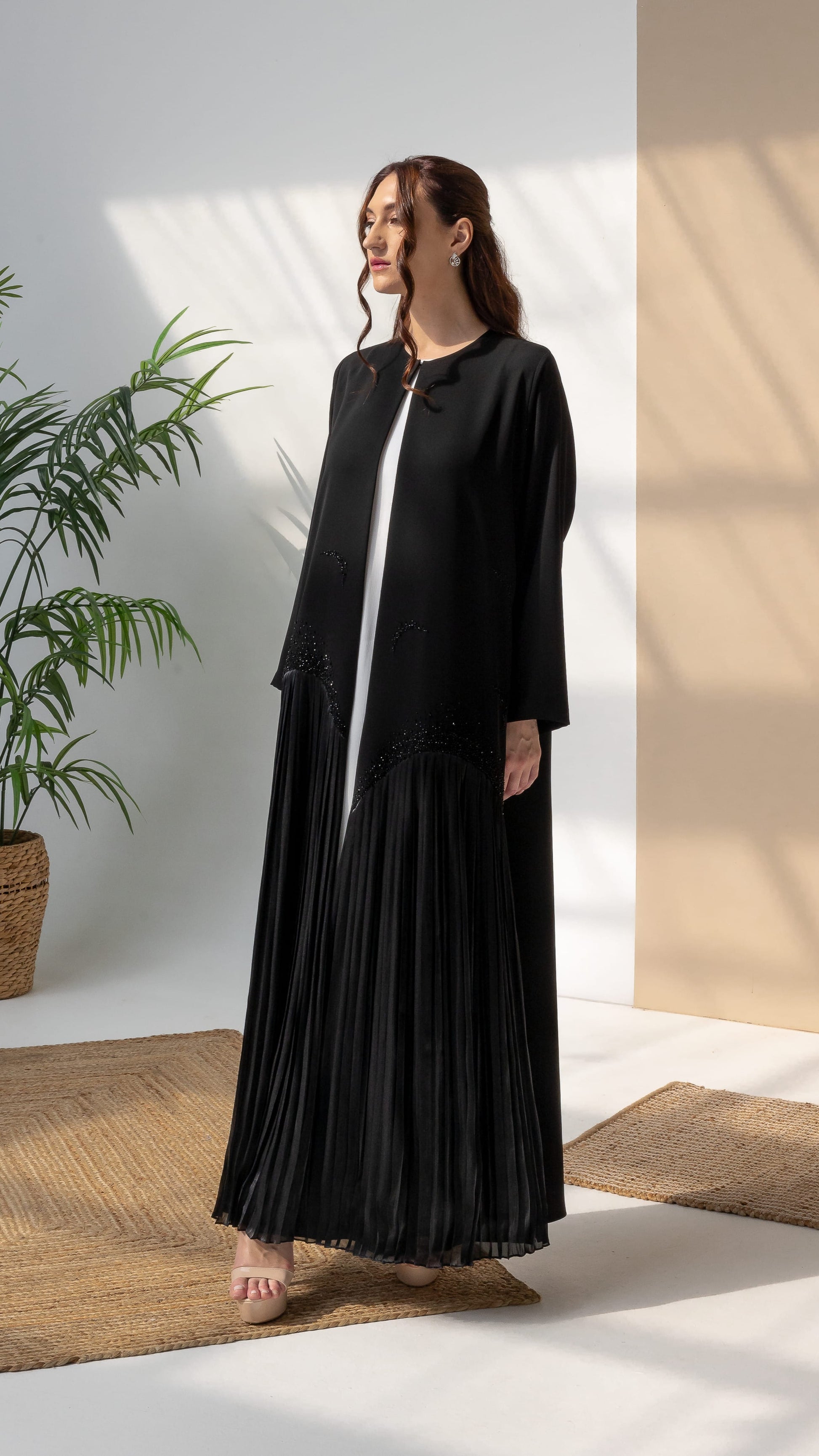 Back movement view of Mira Noir Shadow Luxe abaya showcasing full drape