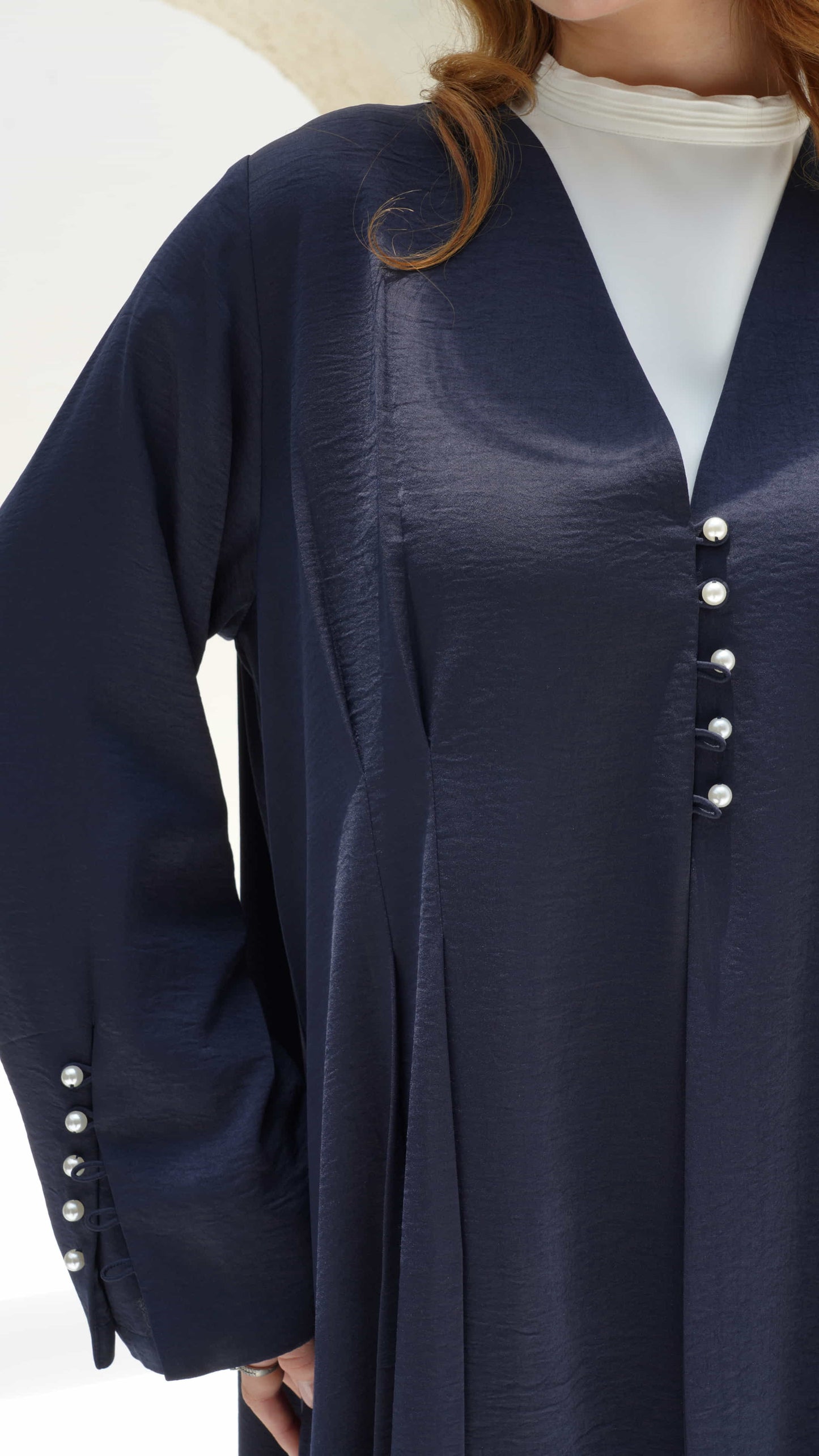 NAILA | Midnight Pearl Close up of pearl button detail on navy abaya front