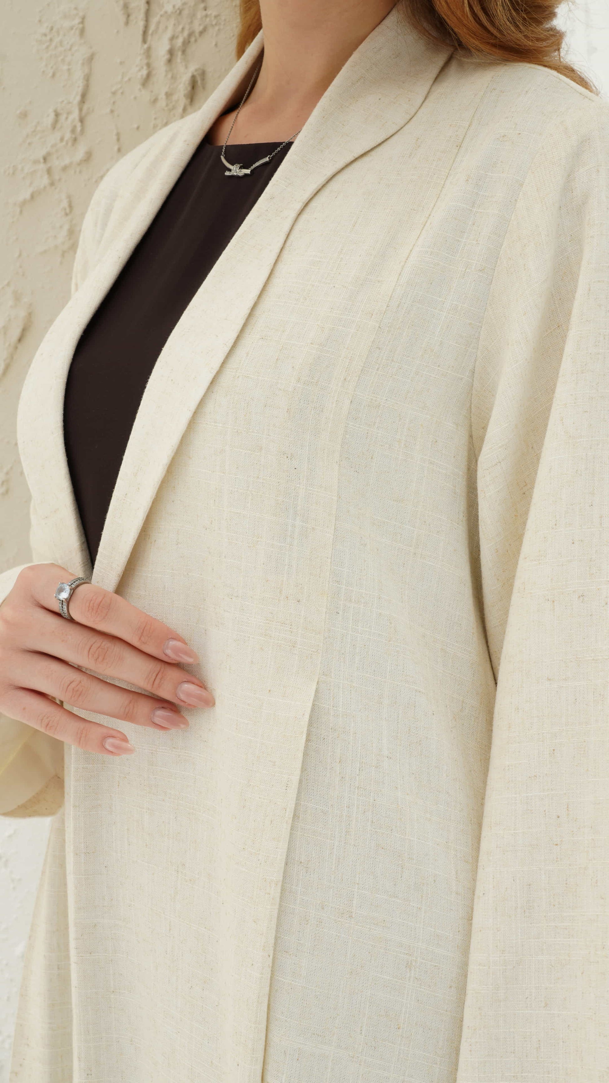 NAIMA | Ivory Elan Close up of ivory abaya lapel detail and refined texture