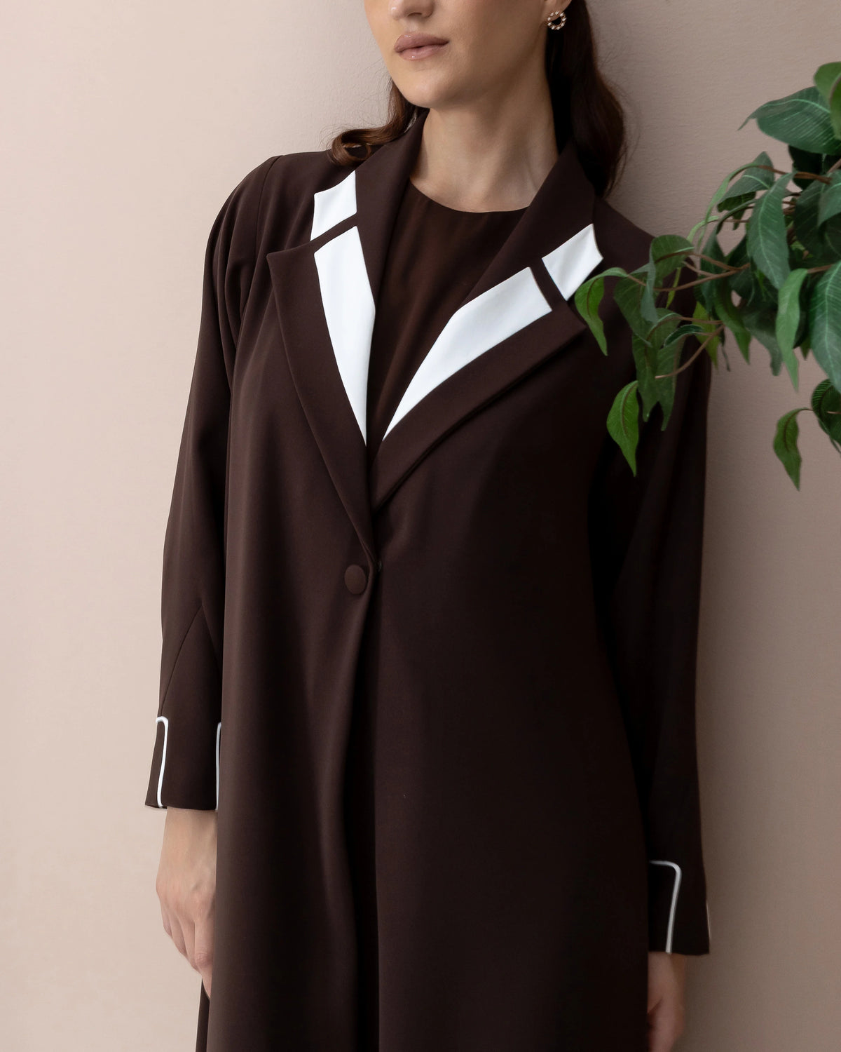 NAZRA Espresso Bianco contemporary abaya with white cuff detailing and structured lapel accents