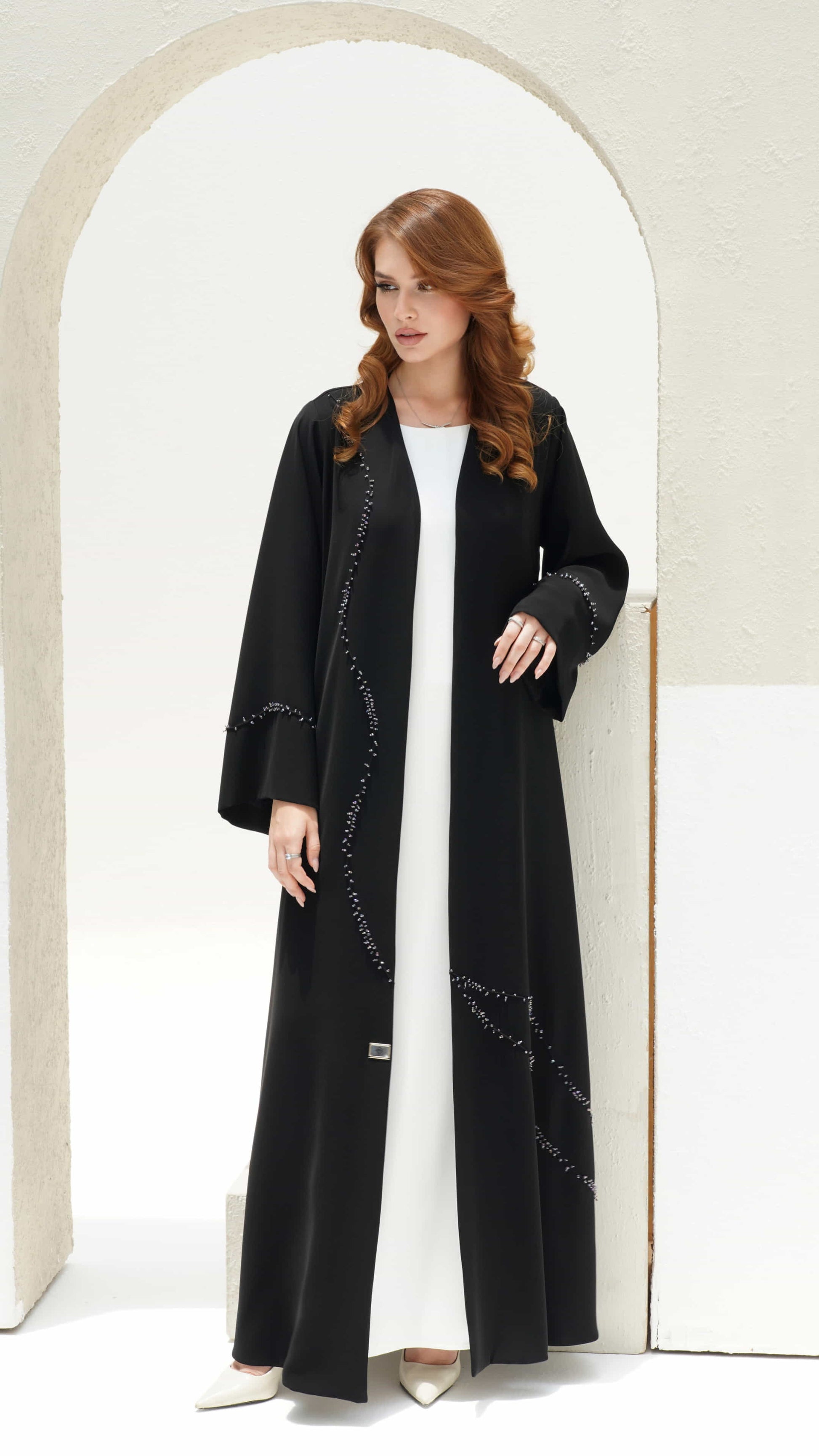 NISREEN | Noir Cascade Side View Minimal luxury black abaya with soft drape silhouette