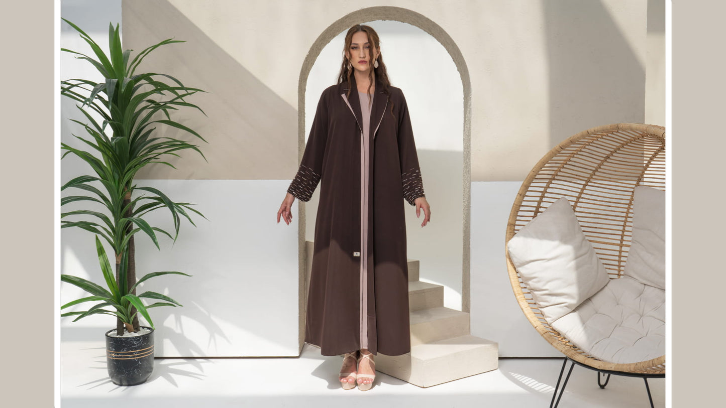RANYA | Cocoa Crystal Rain Model wearing brown abaya with embellished sleeves and minimal luxury styling