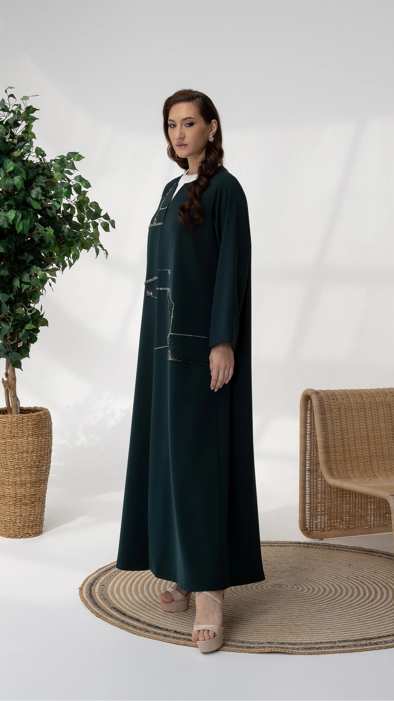 RUBA Emerald Mirage angled pose couture emerald green abaya with flowing silhouette and crystal detailing