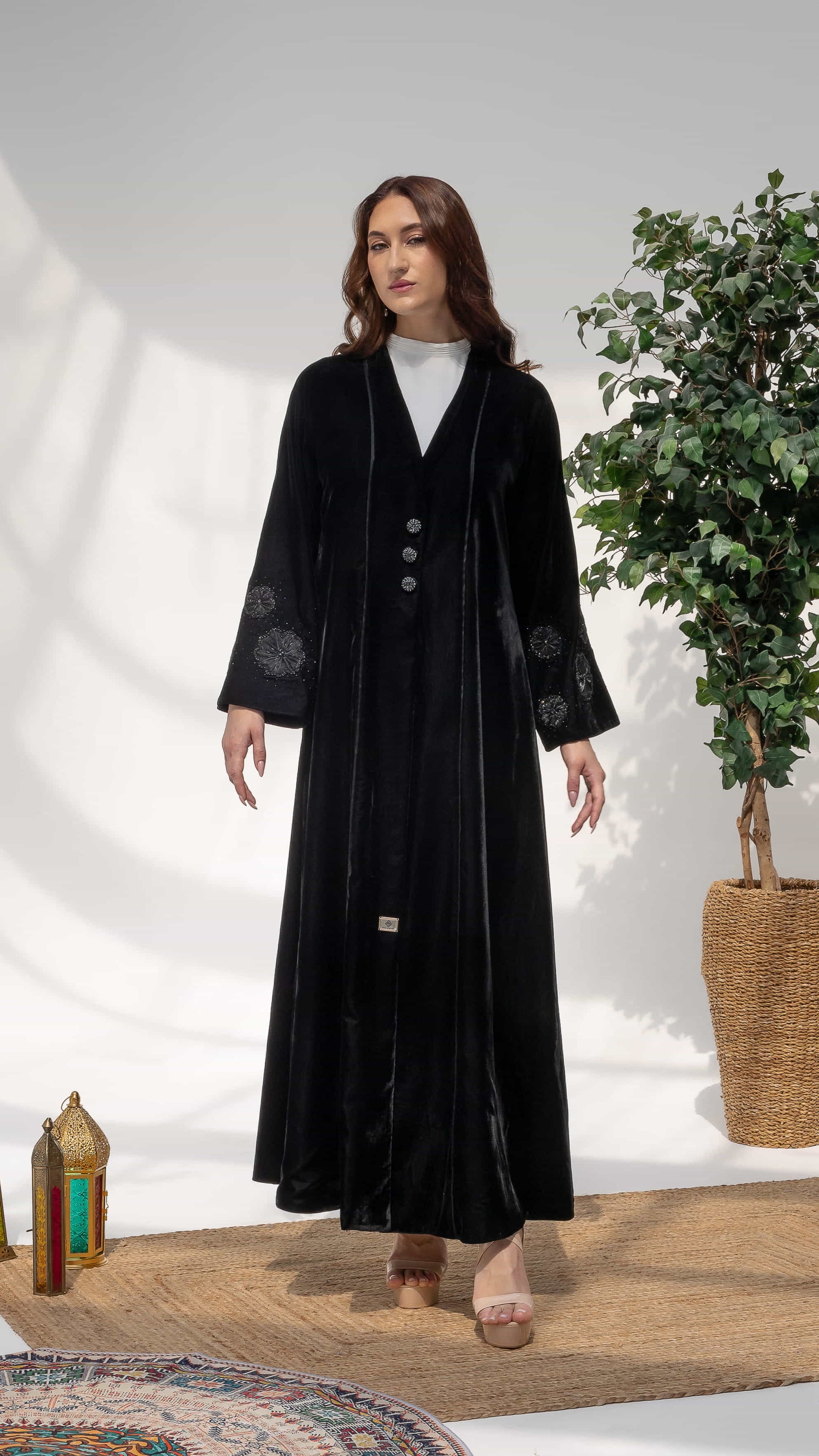 Warda Noir Floral Velvet Abaya by Diva Atelier - Model wearing black velvet abaya with floral embellished sleeves portrait view