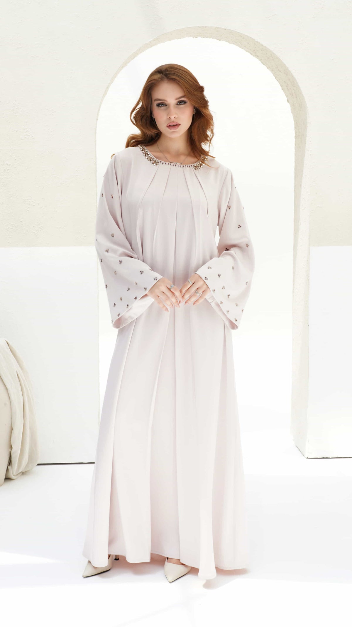 Front view of Zahira Blush Lumiere kaftan showing pleated panels and crystal neckline detailing