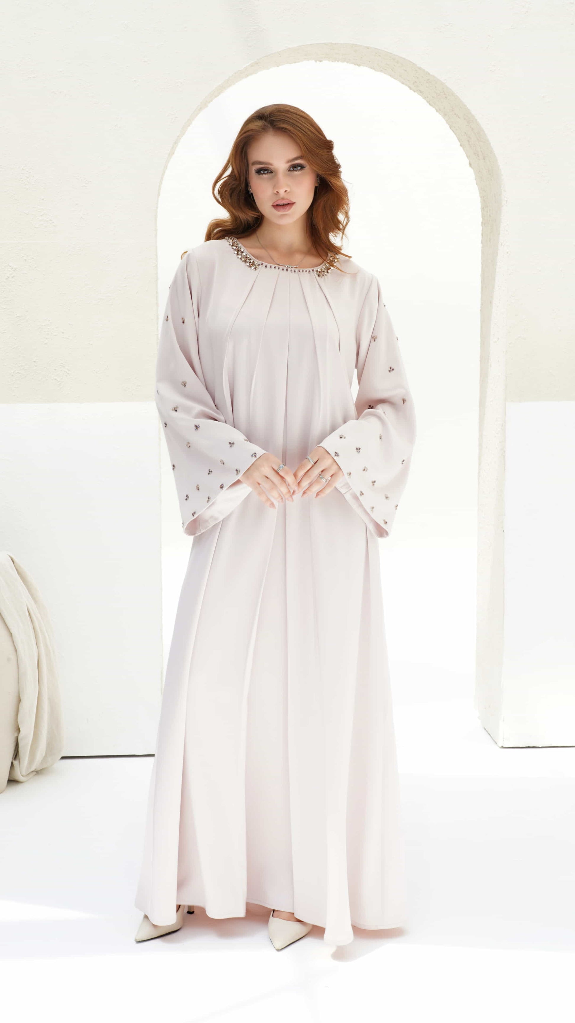 Front view of Zahira Blush Lumiere kaftan showing pleated panels and crystal neckline detailing