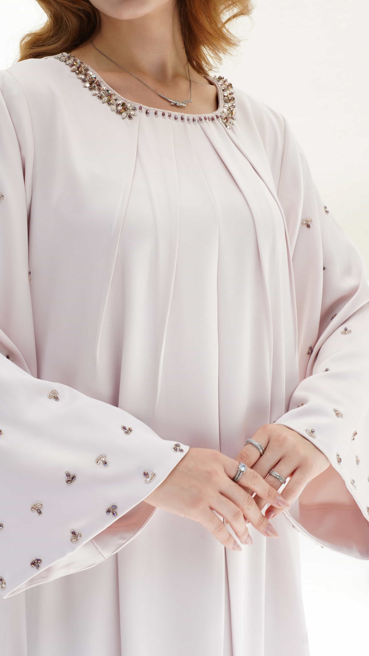 Zahira Blush Lumiere Close-up of Zahira kaftan neckline with hand-set crystals and soft pleated fabric