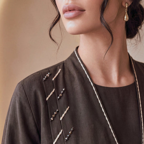 SIDRA espresso linen abaya, hand-set beadwork and ivory piping at the neckline